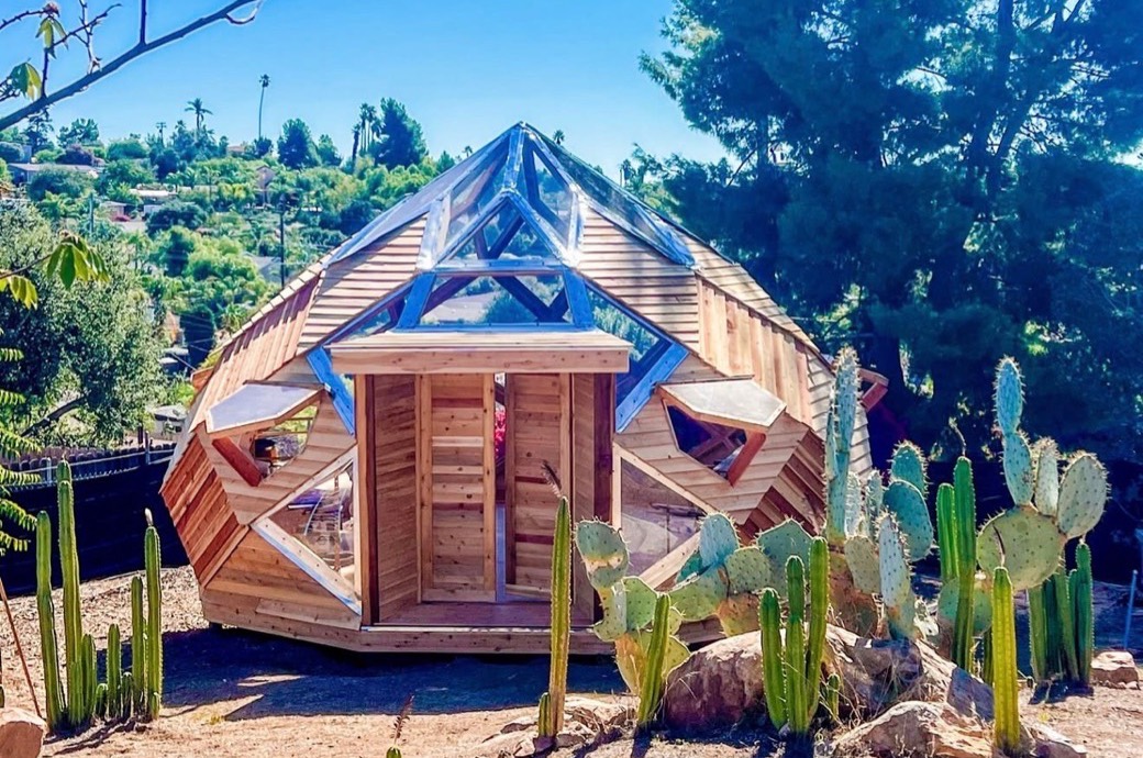 A wooden Trillium Dome with a glass crown, surrounded by cactus